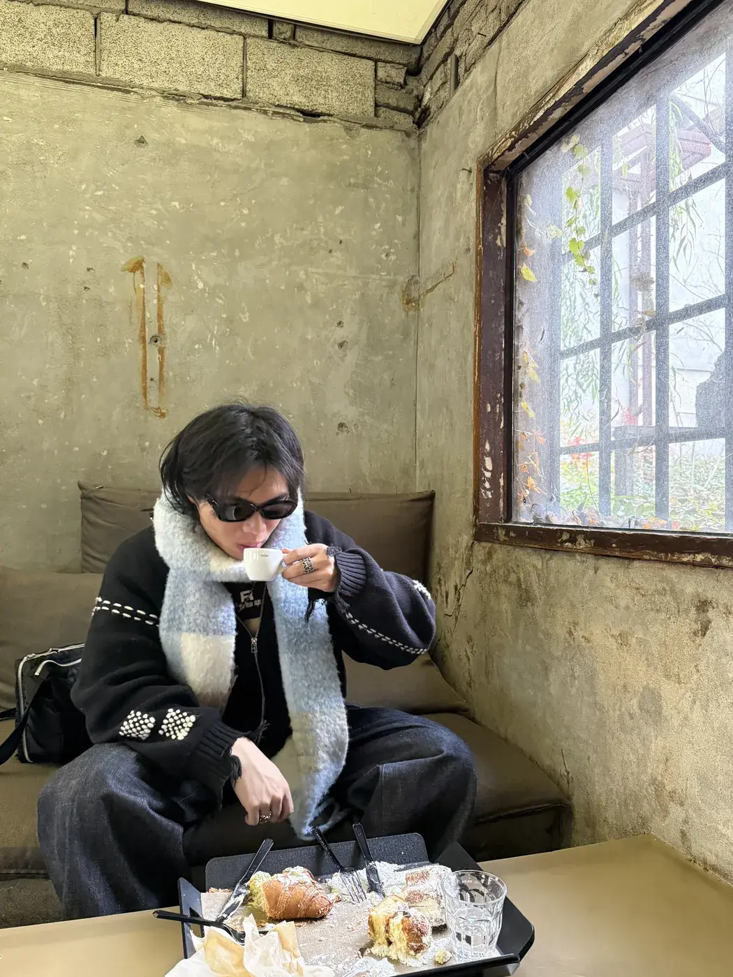 Elliot eating at a small cafe beside an old window