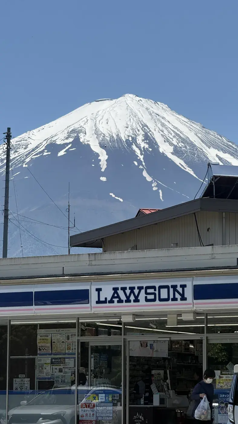 Mount Fuji rising behind a Lawson convenience store