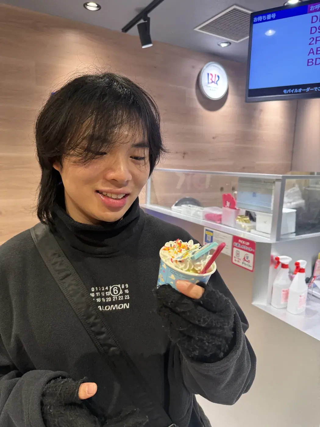 Elliot smiling and holding a cup of ice cream
