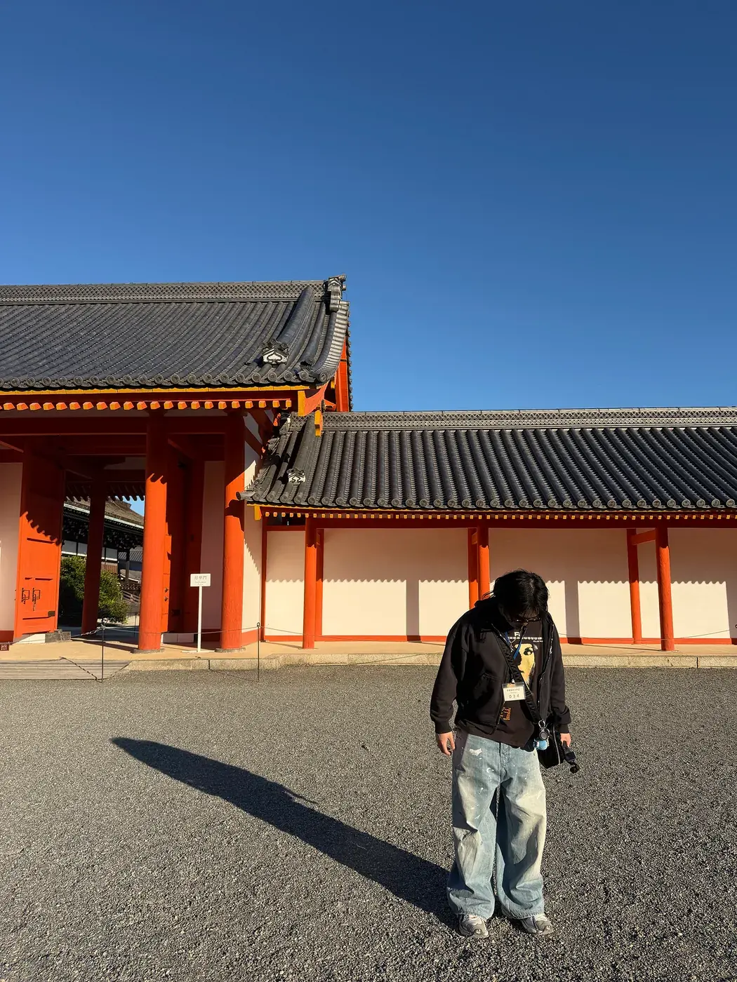 Elliot standing in front of a red shrine gate under a clear blue sky