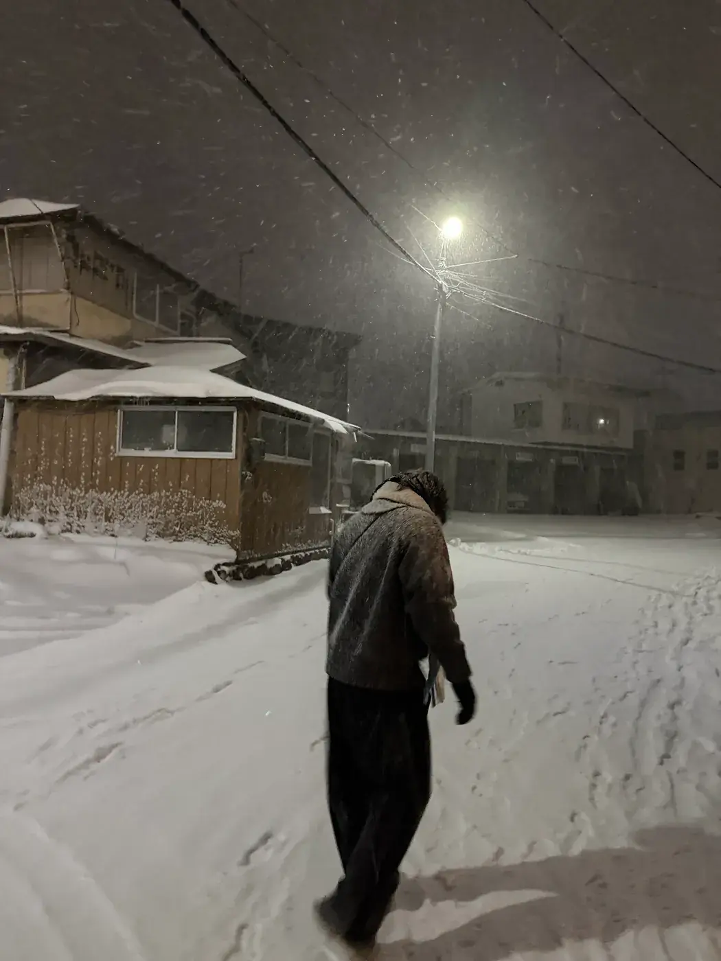 Elliot walking down a snowy street at night